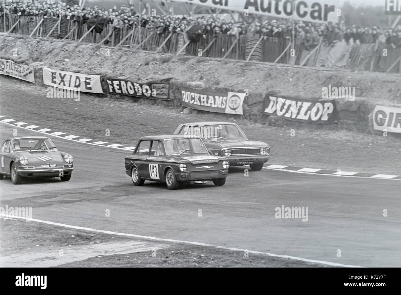 Hillman Imp numéro de course 143, conduit Ford Cortina 565E course UVX, numéro 112, 911 et 60 911F, numéro de course 111, au circuit de course automobile de Brands Hatch en Angleterre durant les années 1960. Banque D'Images