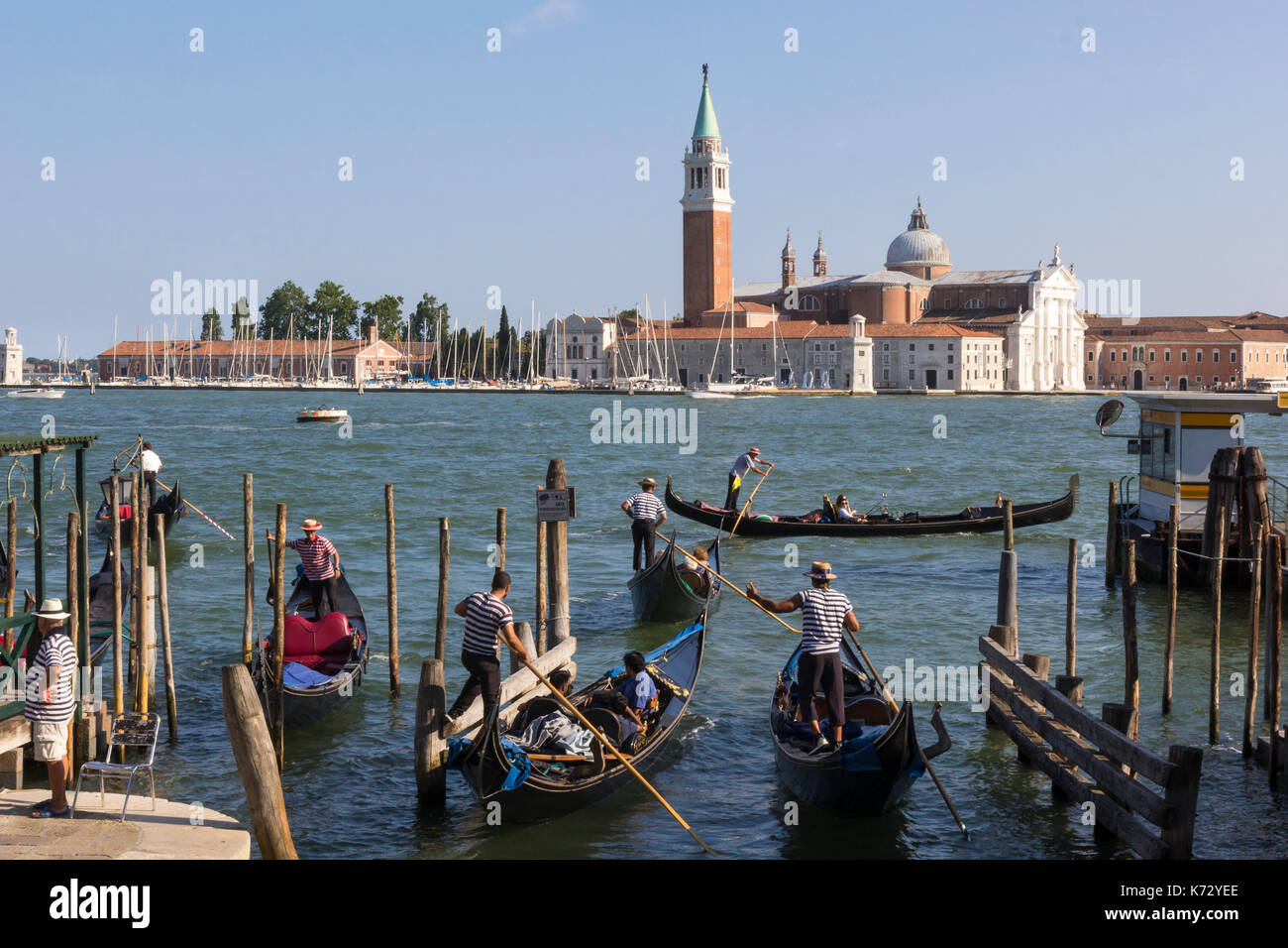 Gondoliers avec leurs gondoles en face de la place San Marco à Venise, Italie. l'île San Giorgio Maggiore est dans l'arrière-plan. Banque D'Images