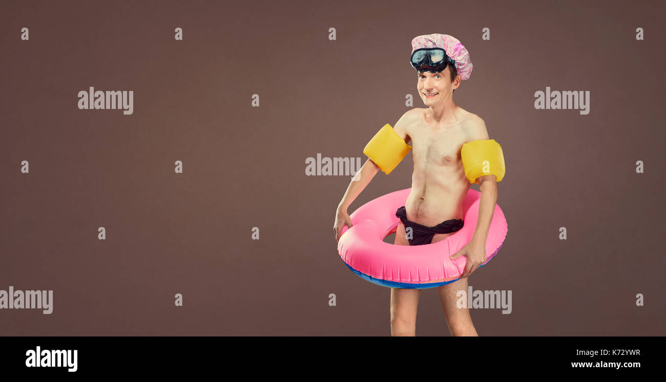 Joyeux drôle homme mince en maillot de bain avec un cir gonflable Banque D'Images