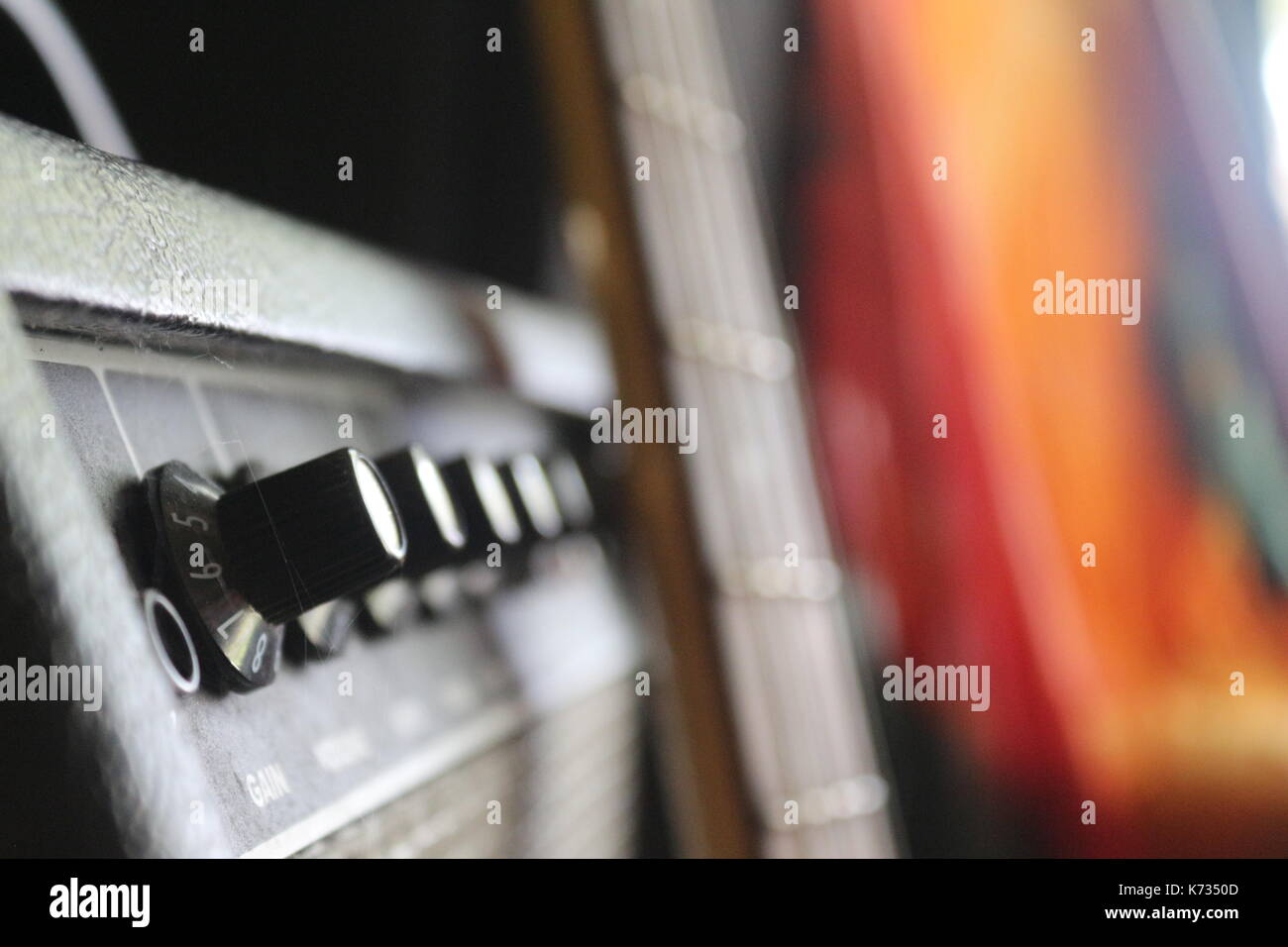 Les musiciens d'une guitare basse et un ampli basse avec un tie dye tapisserie en arrière-plan. Banque D'Images