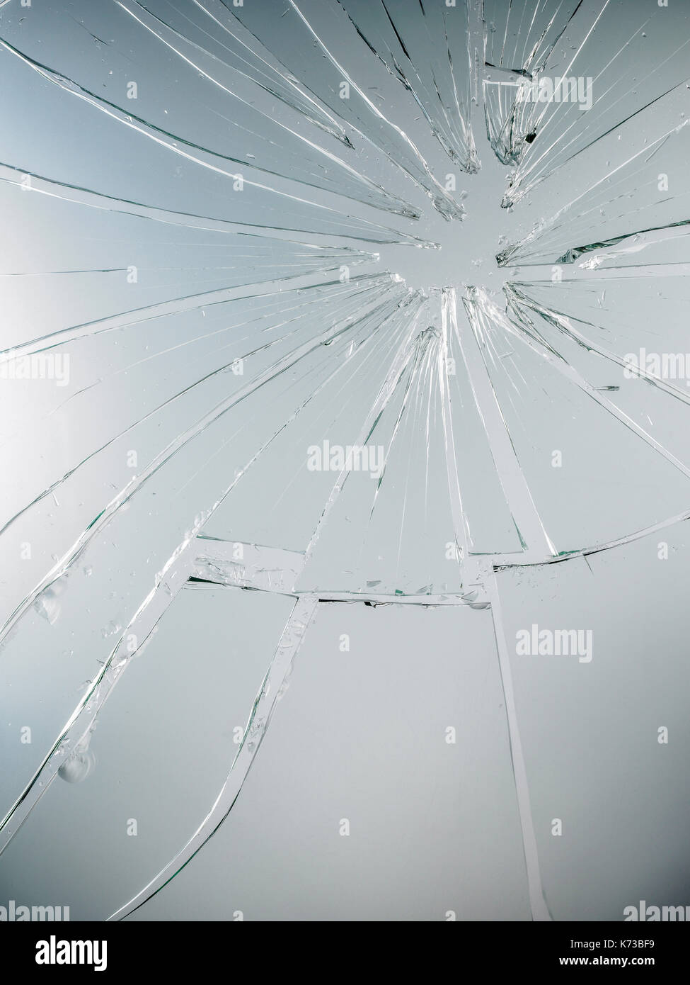 Les fissures dans le verre sur le fond gris Banque D'Images