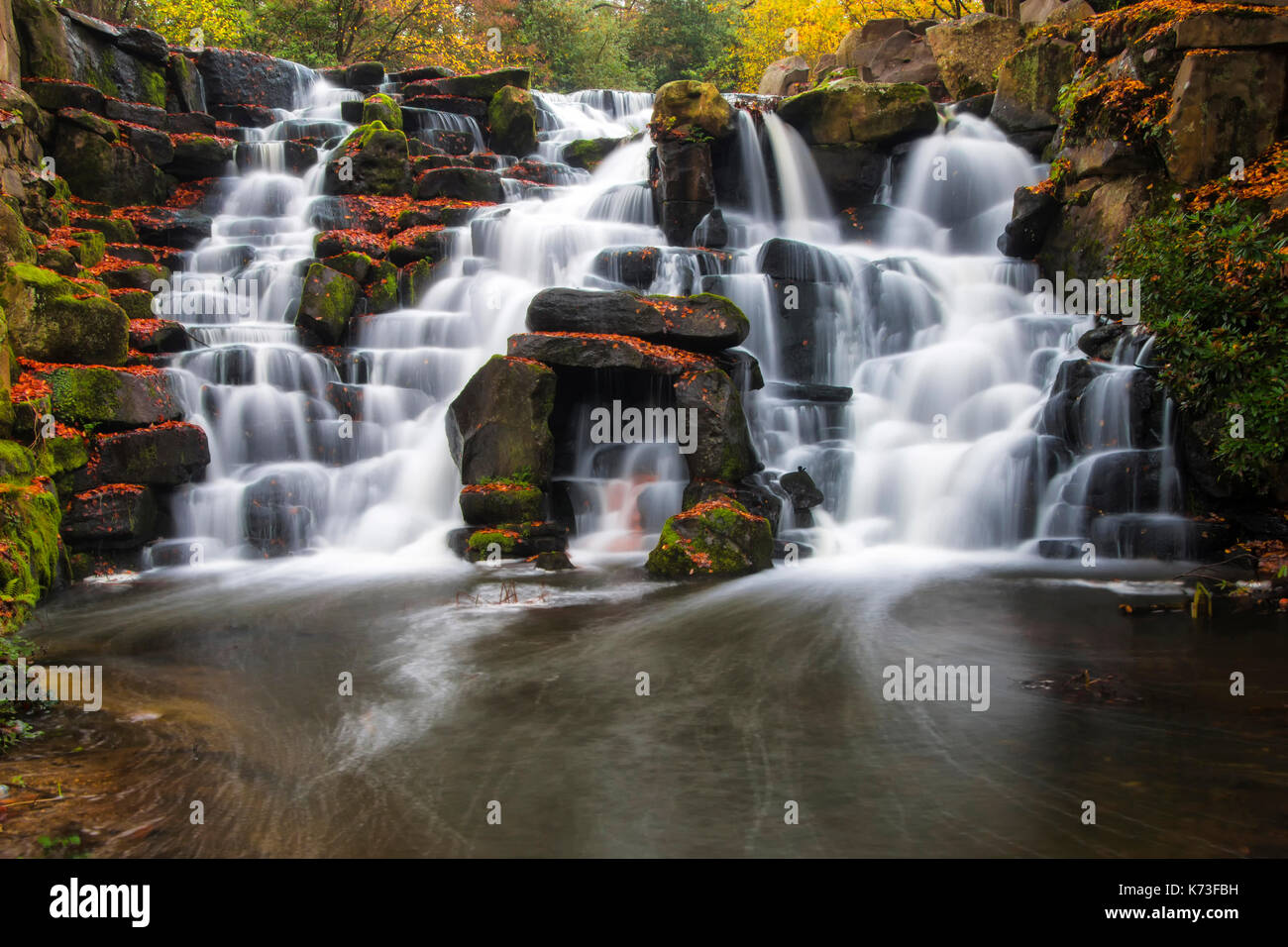 La cascade de cascades en automne. virginia water, Surrey. uk. Une longue exposition donne le flou d'un blanc laiteux d'eau sur les roches Banque D'Images