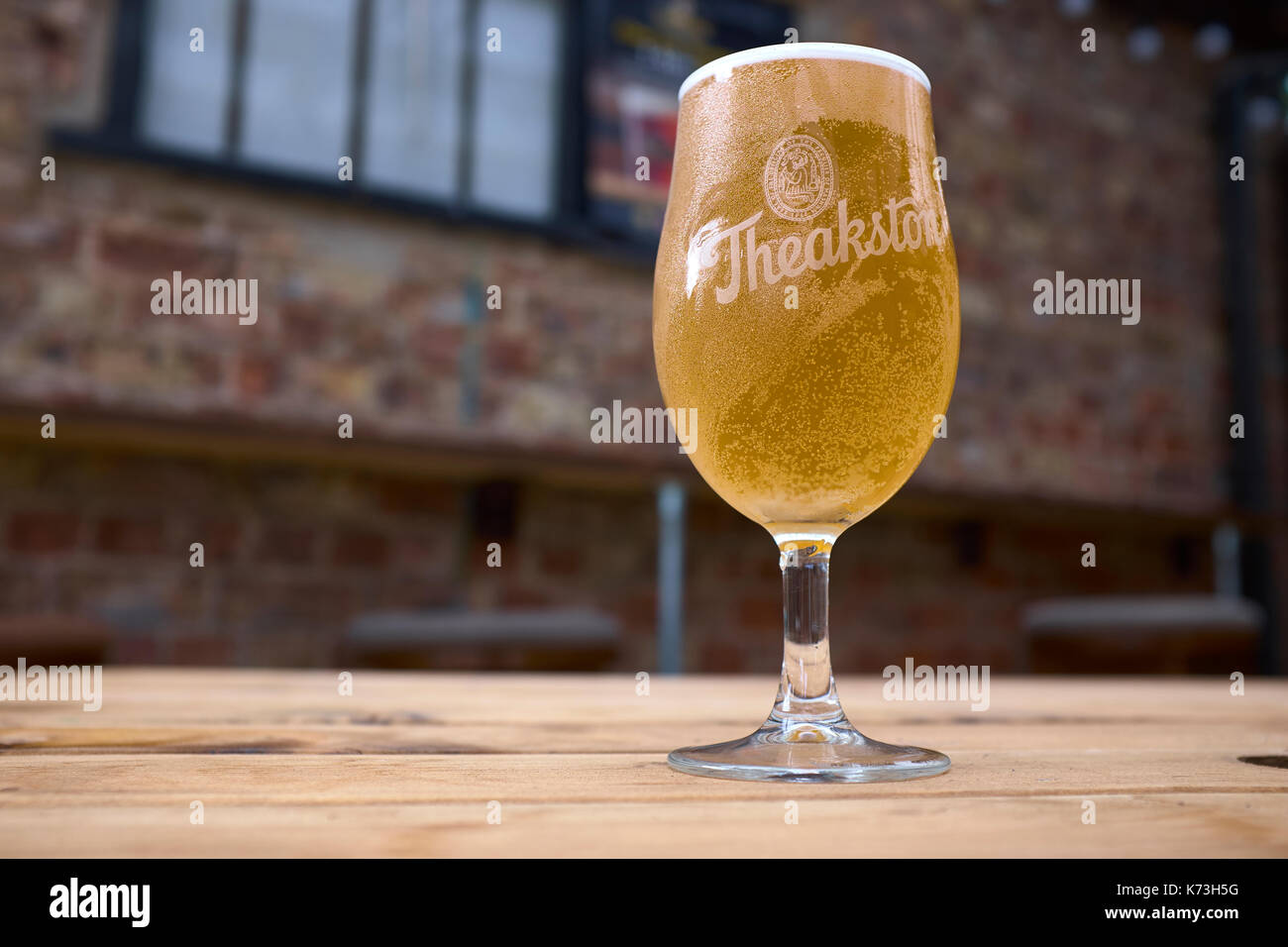 Demi-pinte de bière de Theakston dans un verre a pied sur une table en bois,  Yorkshire, Royaume-Uni Photo Stock - Alamy