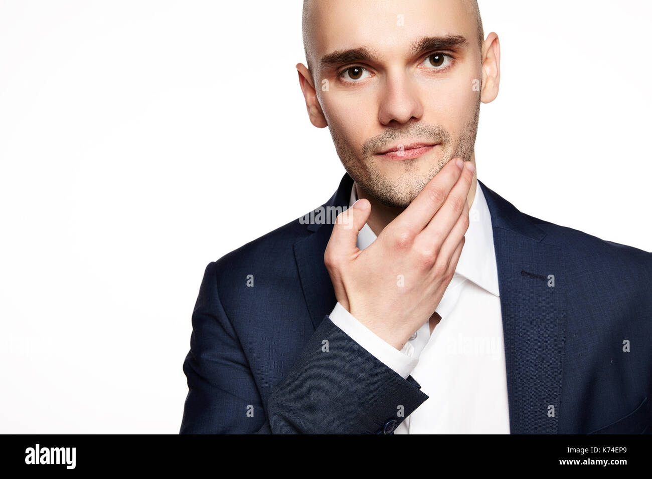 Portrait d'un jeune homme caressant son menton. headshot sur fond blanc. Banque D'Images