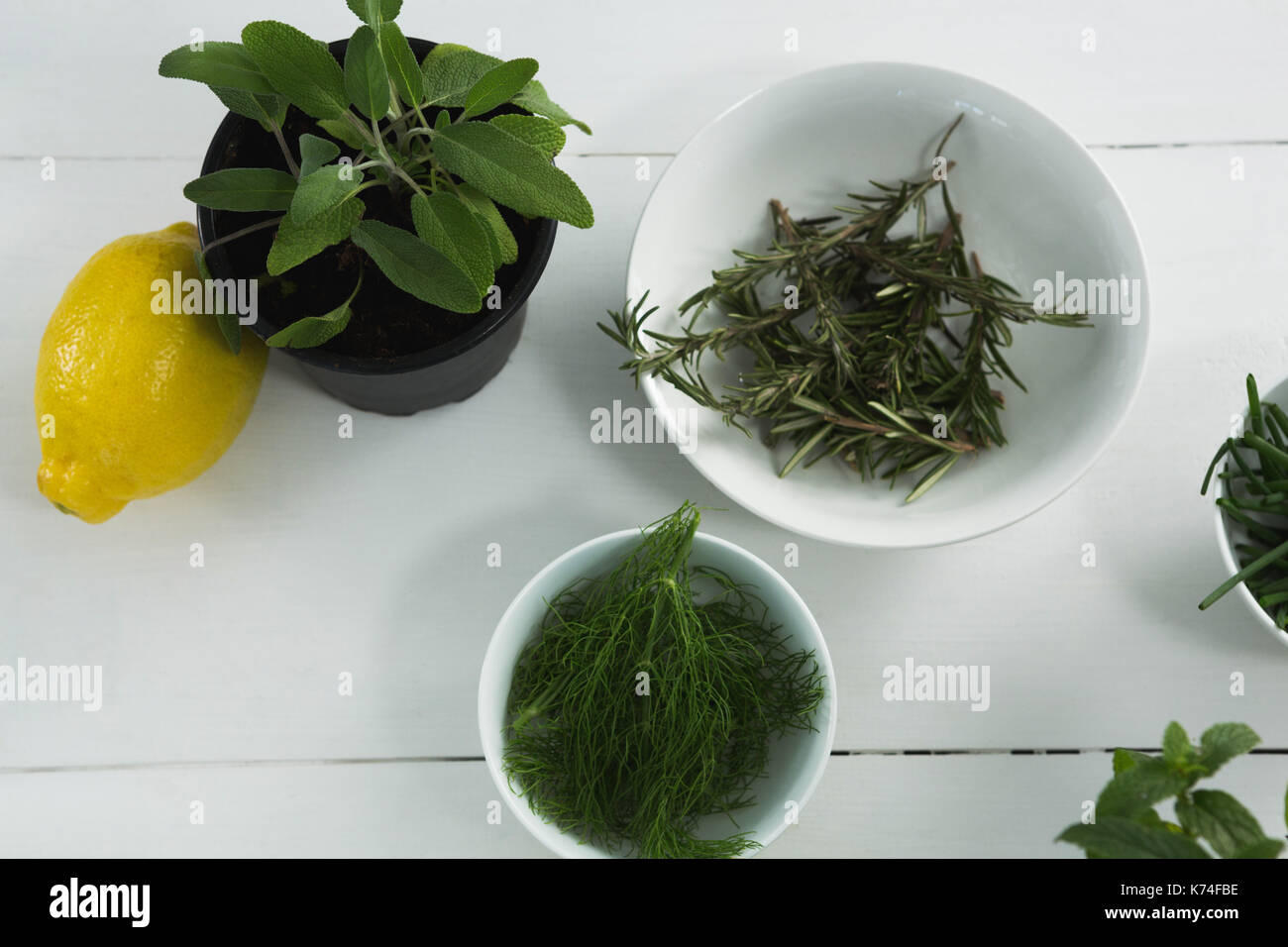 Des herbes dans un bol avec la lime douce sur fond blanc Banque D'Images
