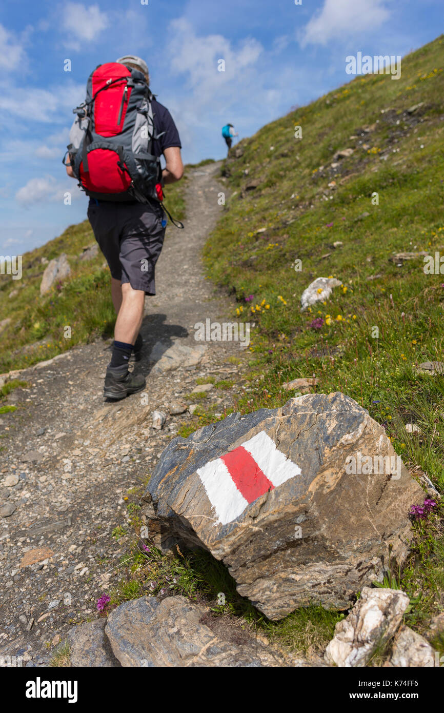 La sauge, Suisse - randonneur et trail blaze du club alpin suisse sur la roche, sur le sentier de randonnée de la haute route, canton du Valais. Banque D'Images