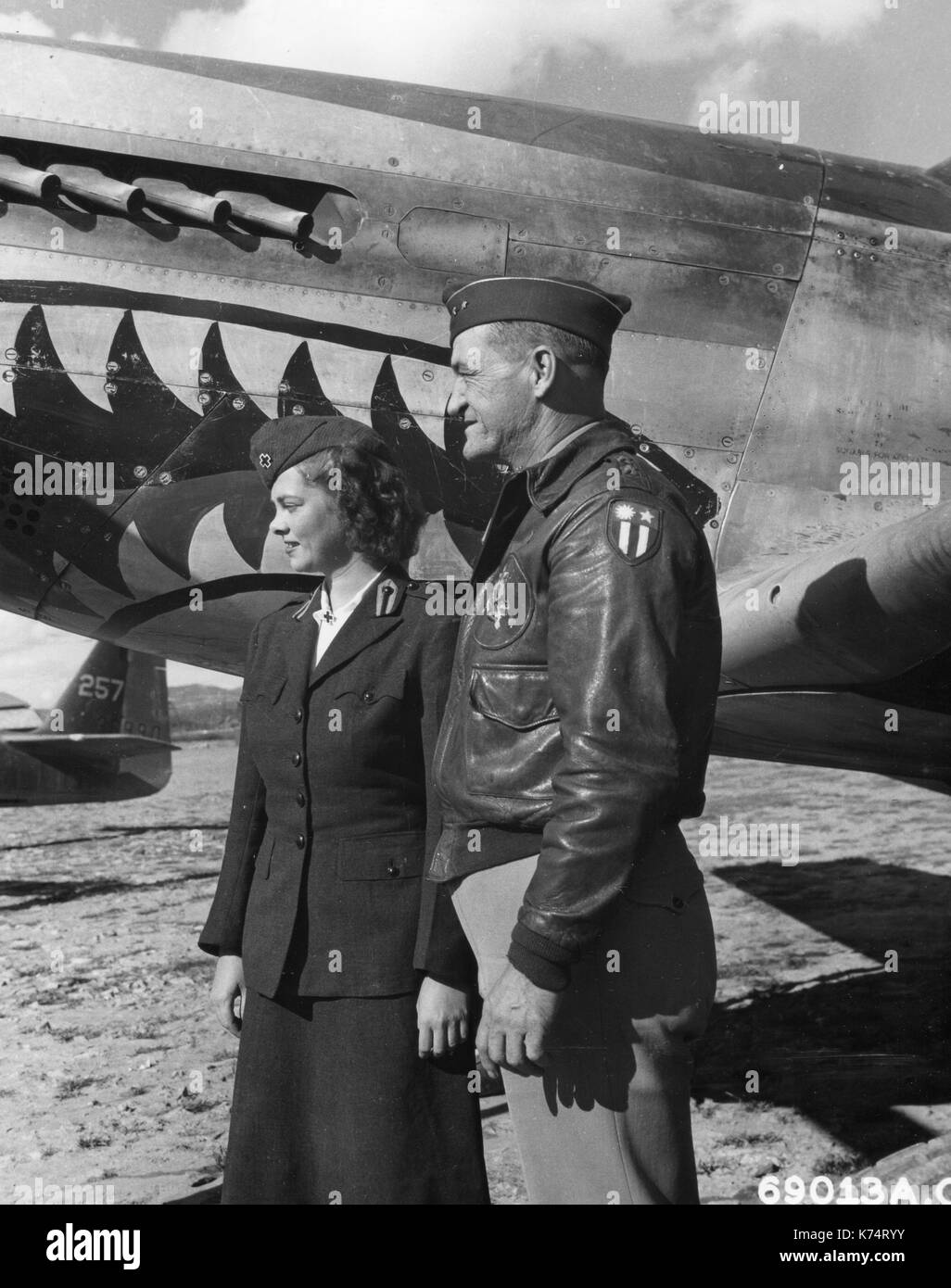 Le Maj Gen Claire L Chennault et une Croix Rouge américaine girl chat ensemble en face d'un North American P-51 Mustang à un Chinois 14e Air Force Base, Chine, 12/22/1944. Banque D'Images