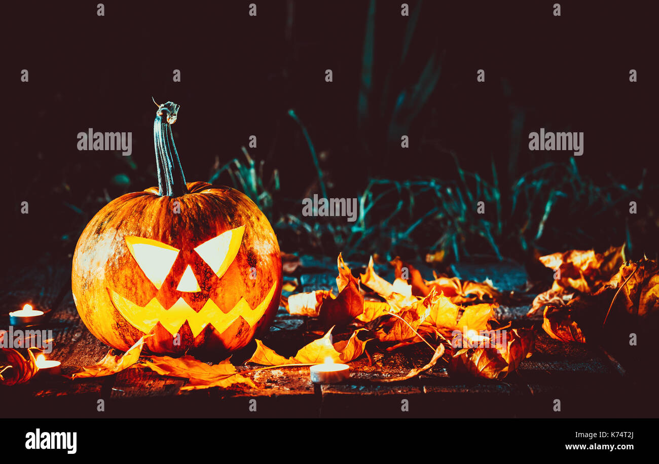 Citrouilles d'halloween tête jack lantern avec bougies autour de l'ancien dans un paysage de nuit fantasmagorique. soft focus dof peu profondes. Banque D'Images
