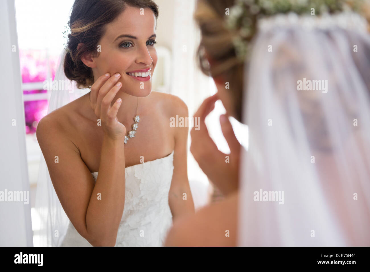 Belle Mariée à miroir en tout en se tenant dans la salle de montage Banque D'Images