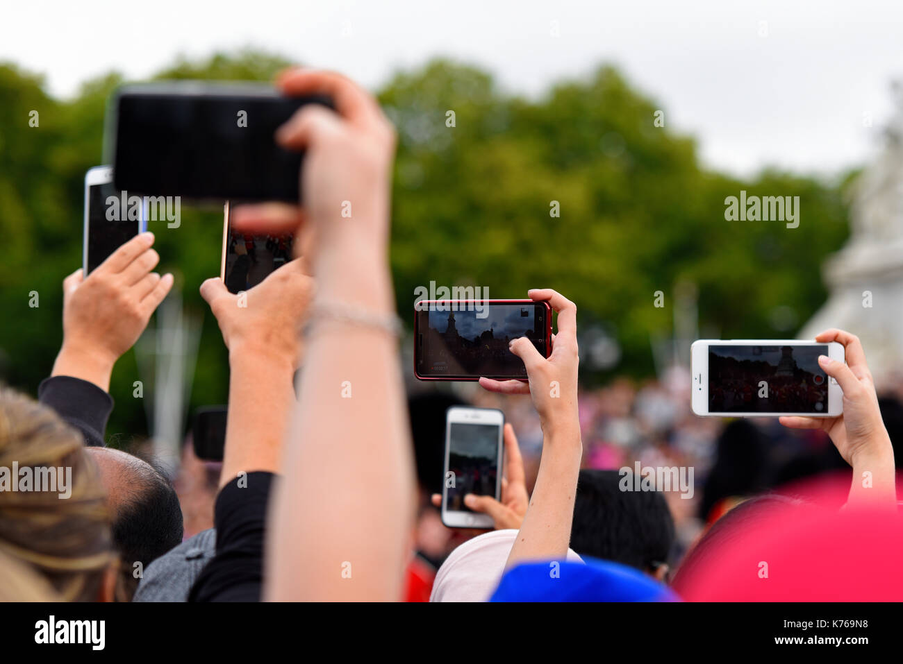Quantité de caméras de téléphone mobile soulevées pour filmer et photographier la relève de la garde en passant l'Édifice commémoratif Victoria à Londres, au Royaume-Uni. Les téléphones intelligents Banque D'Images