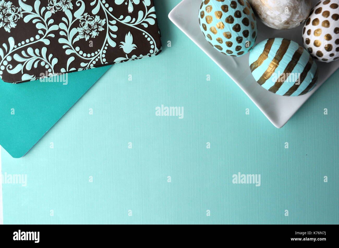 Oeufs de Pâques décorés avec bloc-notes florales et une tasse de thé à la menthe sur fond turquoise bleu sarcelle aqua with copy space Banque D'Images