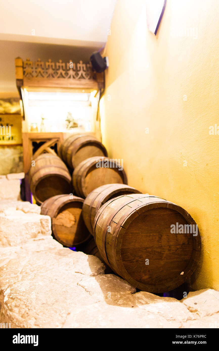 Une variété de différents fûts de bois se trouvent sur le sol en brique près du mur de la winehouse. Banque D'Images