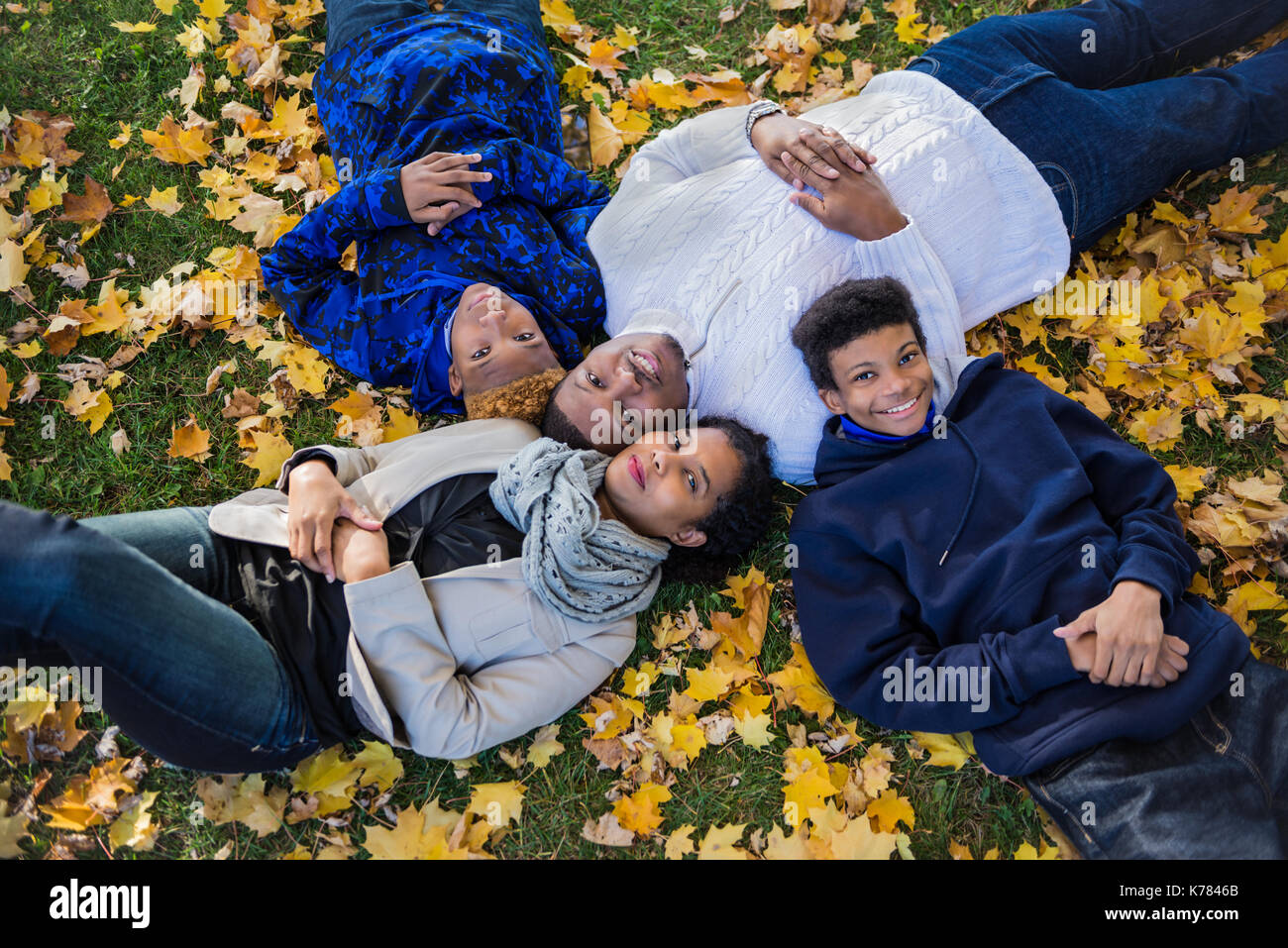 Famille de quatre portant sur les feuilles d'automne, african american family Banque D'Images