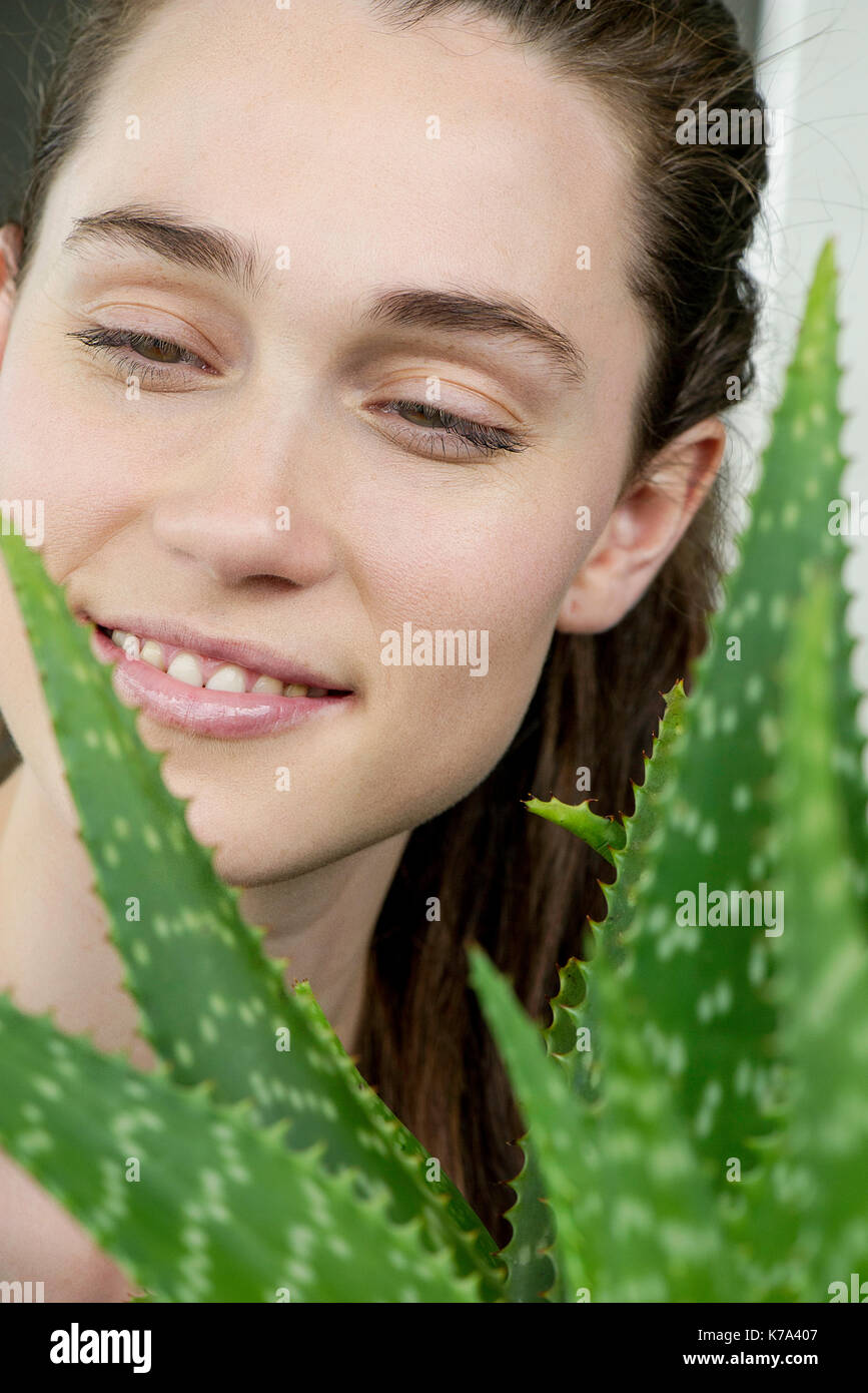 Jeune femme à la recherche à l'usine de vera d'aloès Banque D'Images