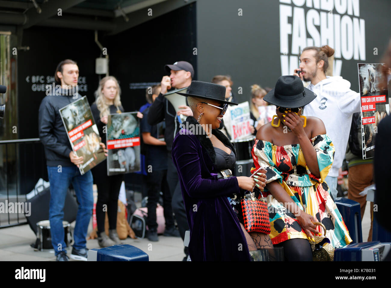 15/09/2017 Londres, Royaume-Uni. London fashion week ss18 et défenseurs des droits des animaux manifesté à l'extérieur de l'espace d'exposition du conseil de mode britannique lors de la London fashion week ss18. Deux fashionistas qui pose pour les photographes. L'un des mode filles porte un manteau de fourrure. défenseurs des droits des animaux a remarqué que cette fille est vêtue d'une fourrure et entouré des filles avec une des affiches la cruauté envers les animaux pour la fourrure. cependant deux filles uniquement à des défenseurs des droits des animaux et continuer de poser pour les caméras. Banque D'Images