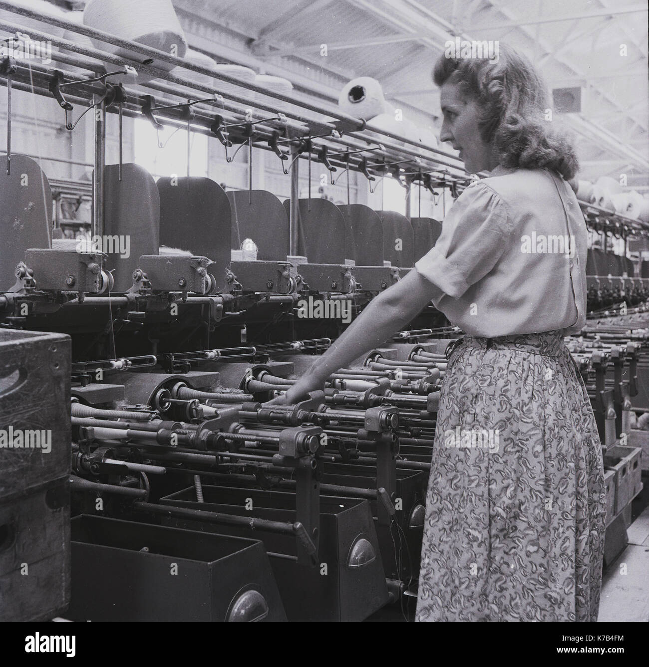 Années 1950, historique, une femme irlandaise travaillant dans une usine de textile, surveillant un certain nombre de métiers mécaniques mécanisés pour tisser des linges, Irlande du Nord. Banque D'Images
