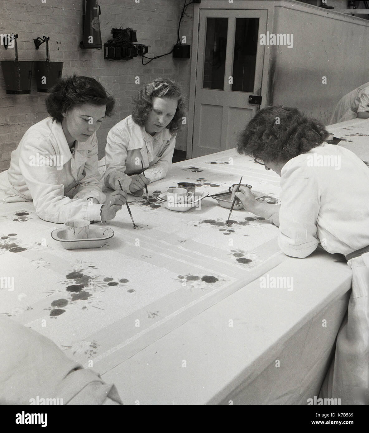 Années 1950, historique, trois femmes du nord de l'irlande peignent à la main des dessins sur le tissu de lin, un produit irlandais traditionnel, une fibre produite à partir de la plante de lin (mauvaises herbes) cultivée et récoltée dans de nombreuses parties de l'Irlande. Banque D'Images