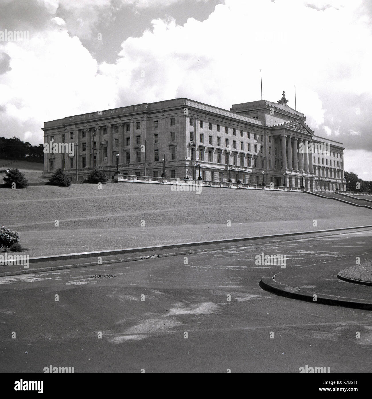 Années 1950, vue historique et extérieure du Parlement et du parc environnant à Stormont, Belfast, Irlande du Nord. Le domaine de Stormont a été acheté en 1921 à la suite de la partition de l'Irlande et le grand bâtiment vu ici, créé dans le style classique grec et fabriqué à partir de Portland Stone, a été officiellement ouvert en 1932. Depuis 1998, c'est le lieu d'administration du gouvernement décentralisé pour le pays, l'Assemblée de l'Irlande du Nord. Banque D'Images