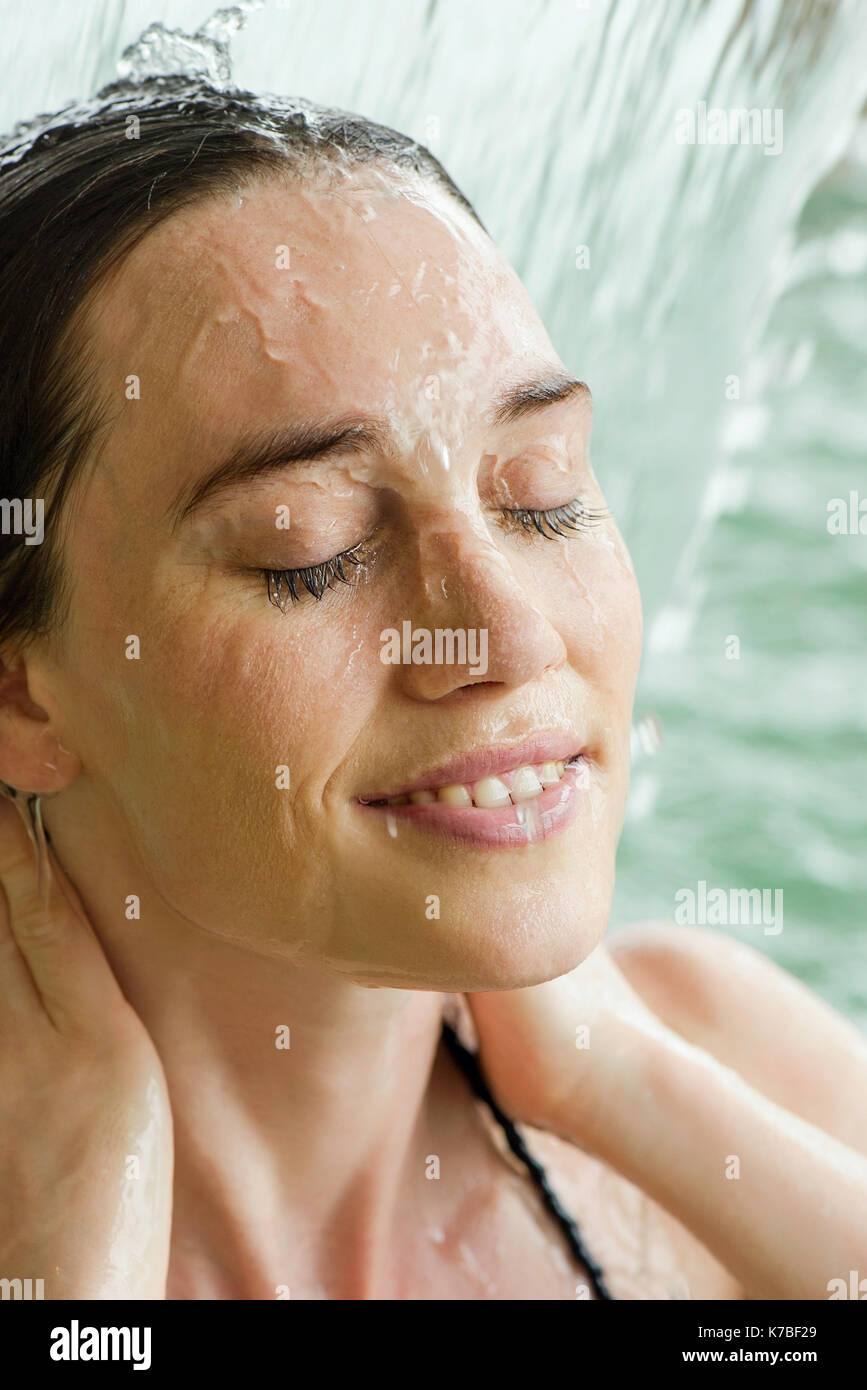 Woman bathing in cascade artificielle Banque D'Images