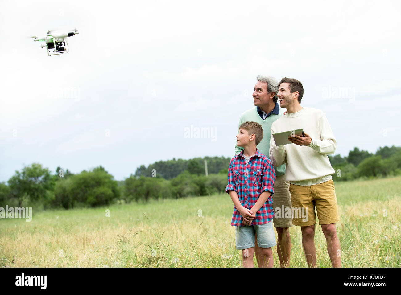 Multi-generation family Playing with drone in field Banque D'Images