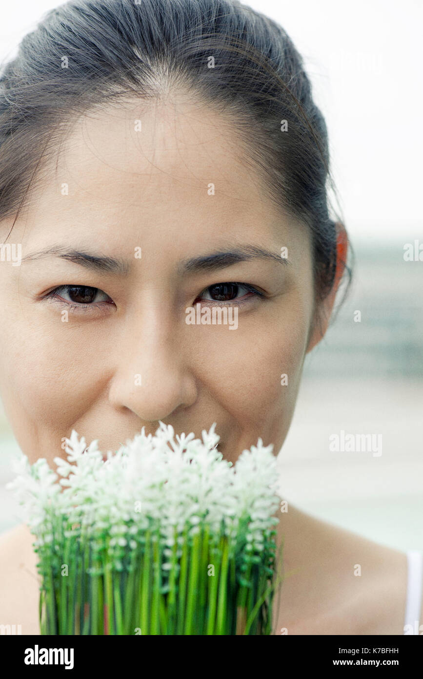 Woman smelling flowers Banque D'Images