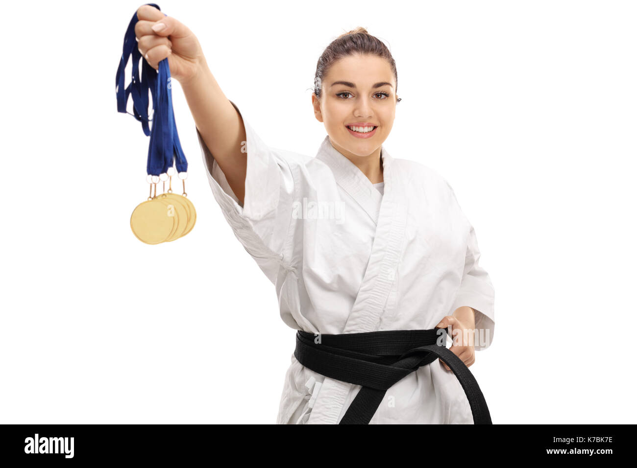 Karate girl montrant médailles d'or et smiling isolé sur fond blanc Banque D'Images