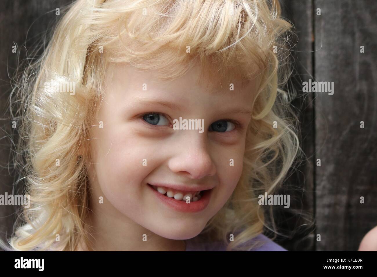 Portrait d'une jeune fille blonde avec un sourire malicieux Banque D'Images
