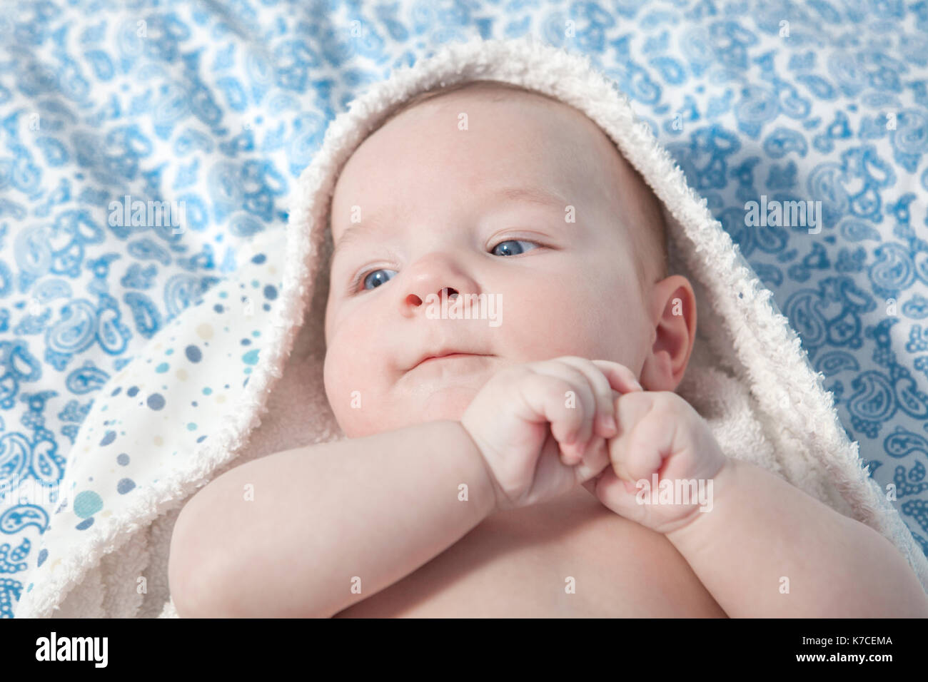 Mignon bébé enveloppé de trois mois de serviette de bain après bain au lit à la maison Banque D'Images