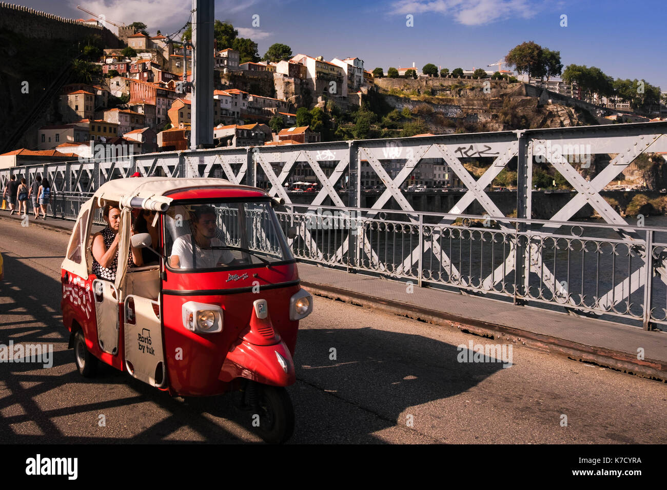 Tuk tuk rouge en voiture des touristes sur le Ponte Luis à Porto, Portugal. Ce type de transport touristique est en train de devenir très populaire dans toute la ville Banque D'Images