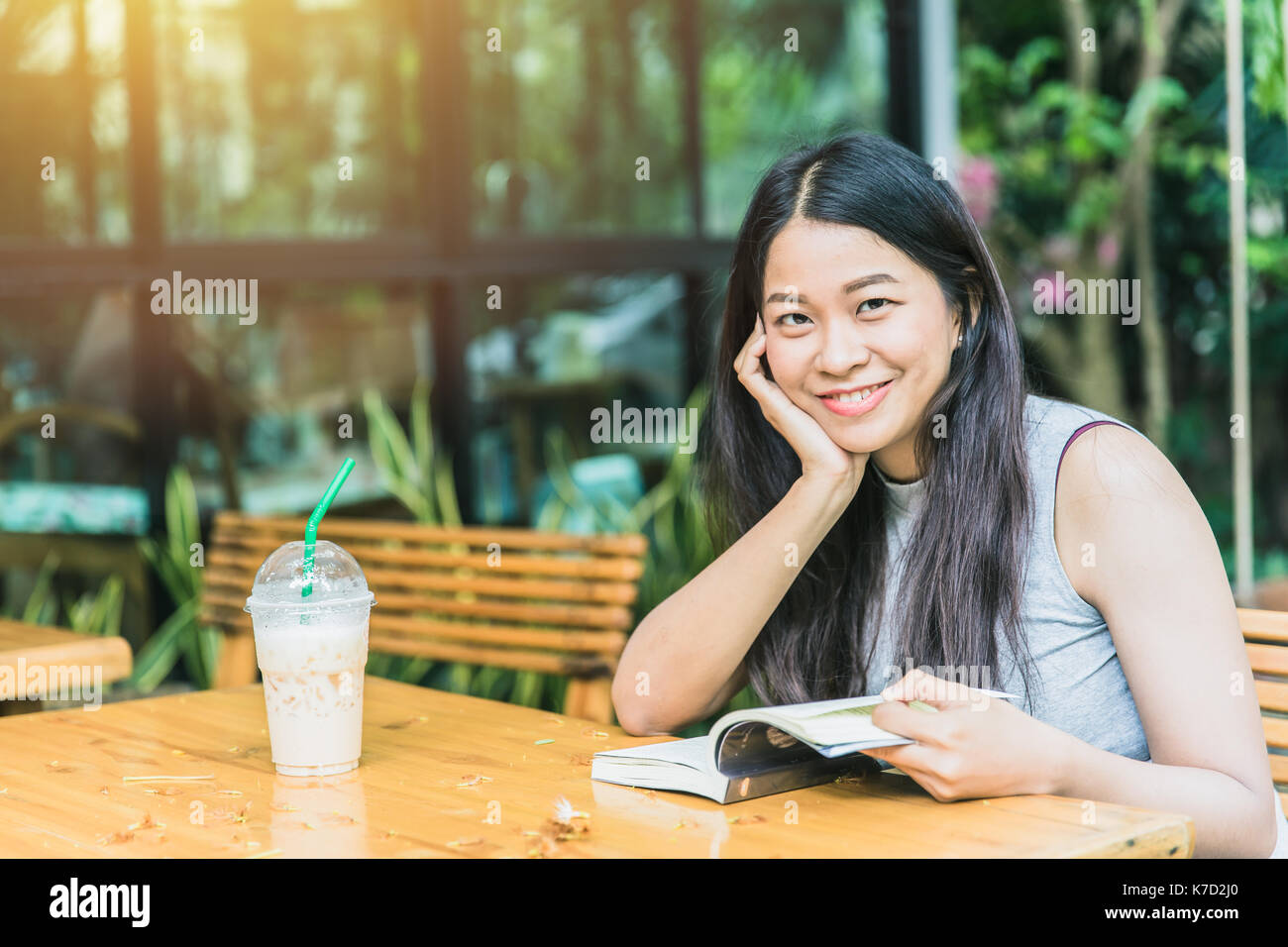 Profitez de moments de détente avec lecture du livre, les femmes asiatiques thai teen sourire avec réserve en coffee shop vintage color tone Banque D'Images