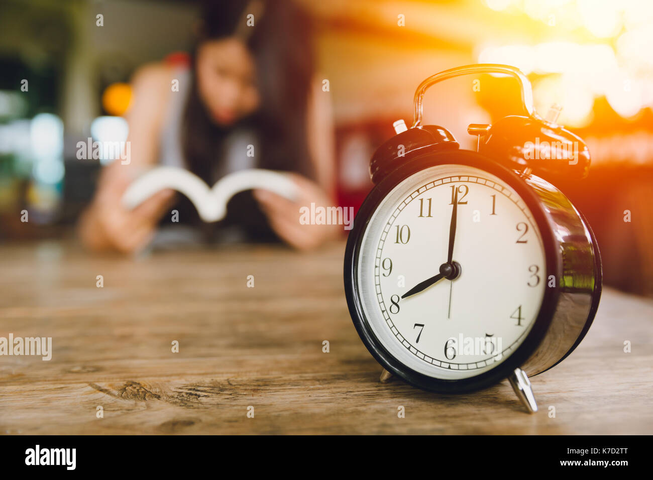 8 o'clock Horloge rétro avec bell personnes lire un livre historique. lecture tous les jours concept. Banque D'Images