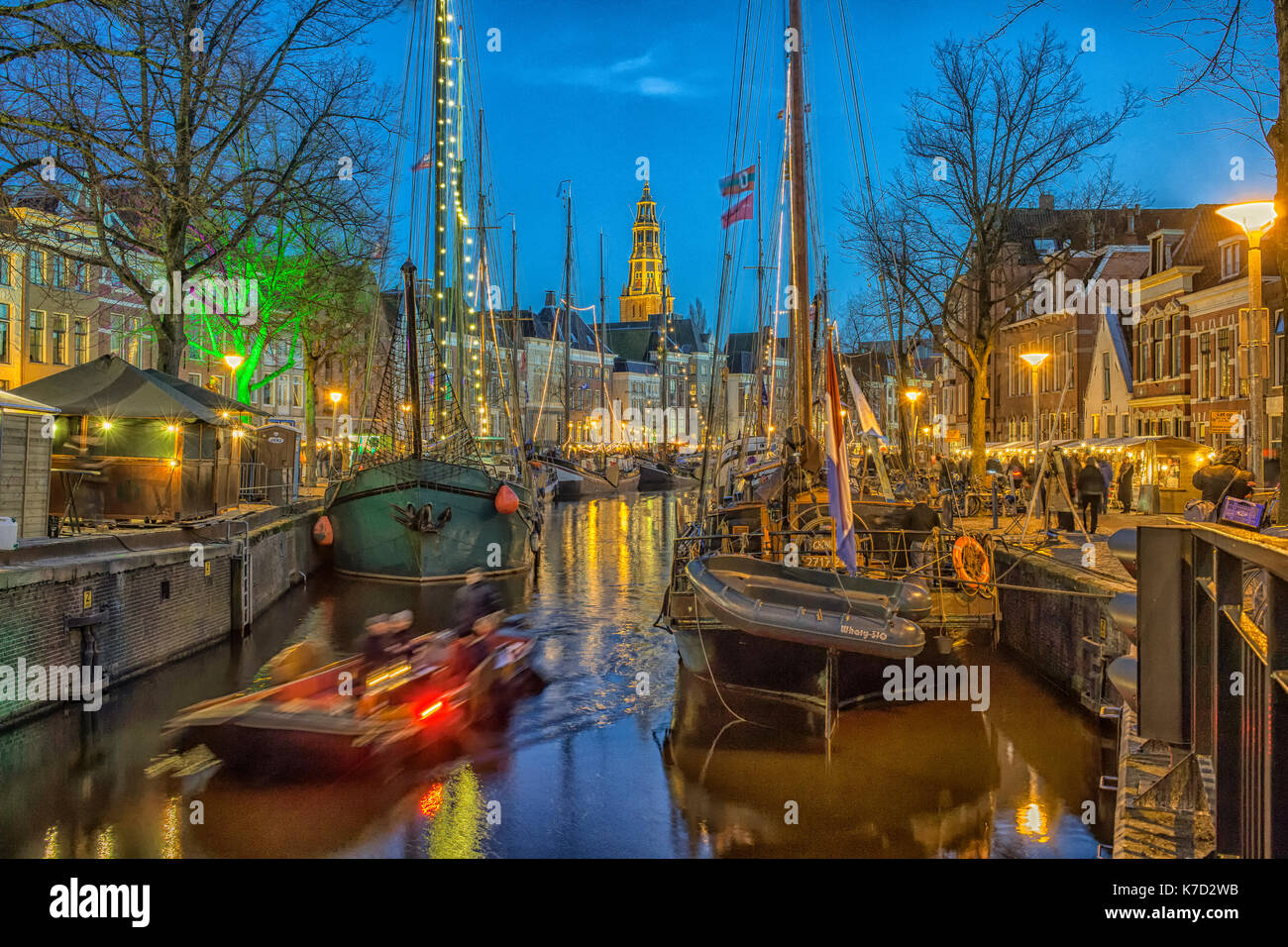 Les bateaux à voile et une vieille-église à l'événement 'winterwelvaart» à Groningen, en Hollande. Banque D'Images