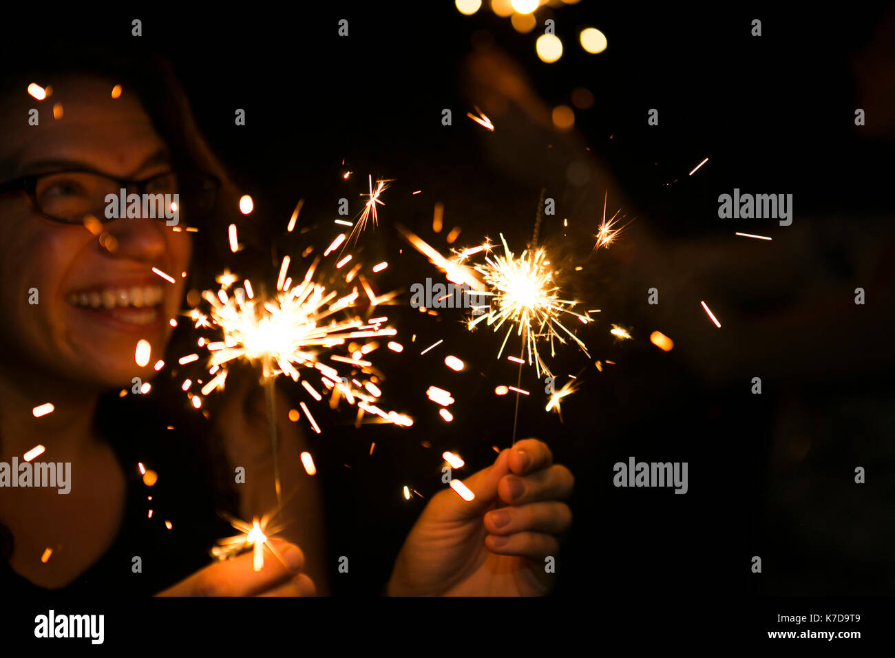 Happy woman holding sparklers Banque D'Images