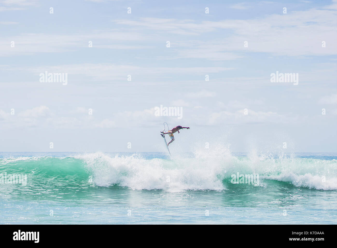 Homme déterminé sur d'énormes sauts surfer les vagues de la mer contre le ciel Banque D'Images