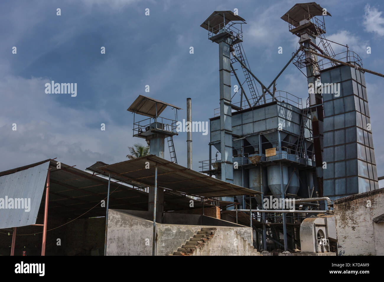 Mysore, Inde - le 27 octobre 2013 : dans ranganathapur, un moulin à riz industriel montre les silos de spathes et arbres, les échelles et les tuyaux pour les charger sous blu Banque D'Images