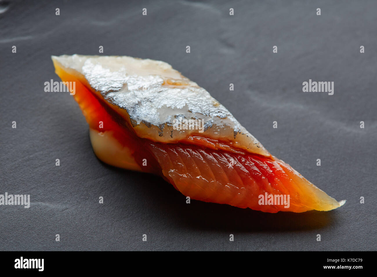 Bota macro closeup on sardine coupe plat en ardoise noire Banque D'Images