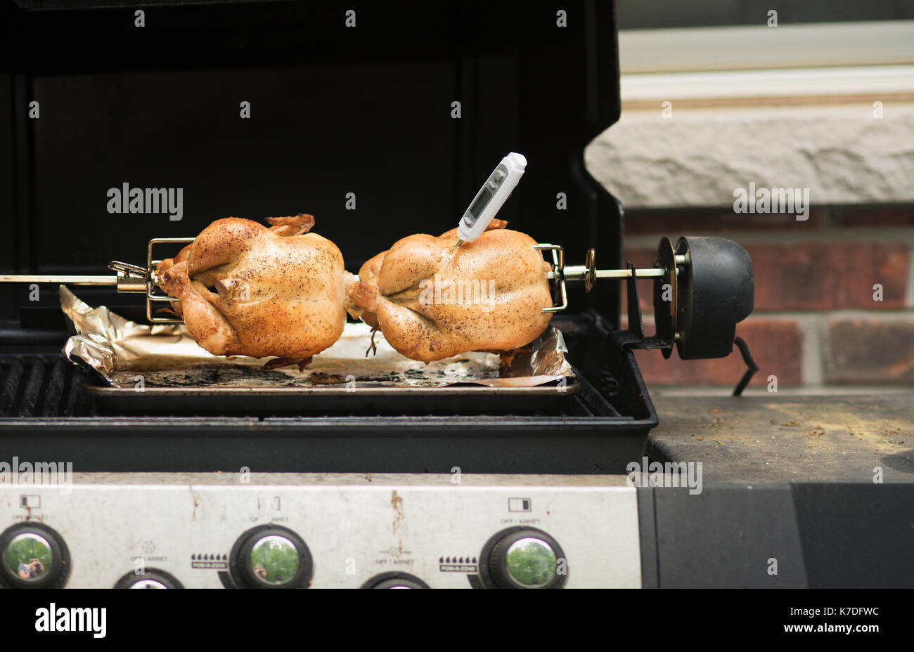Thermomètre à viande inséré dans le poulet tandoori grillées sur barbecue Banque D'Images