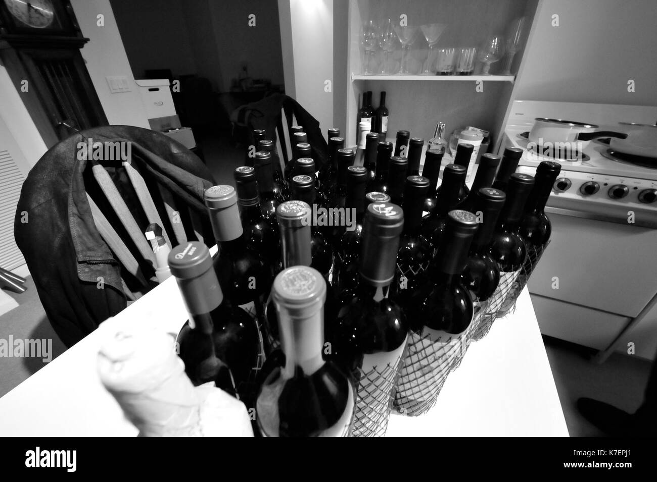 Photo en noir et blanc de bouteilles de vin sur un comptoir de cuisine Banque D'Images