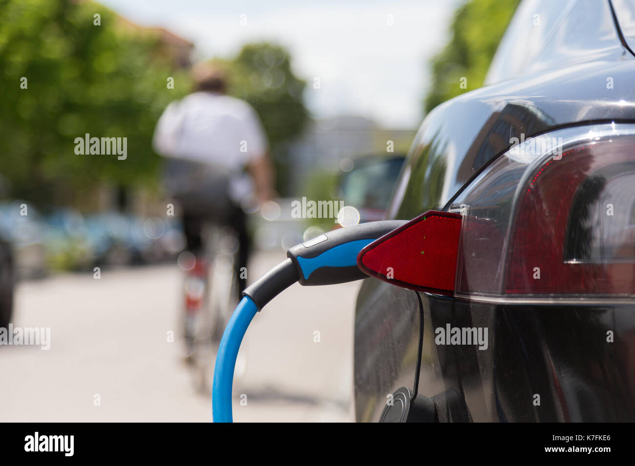 Bloc d'alimentation branché sur une voiture électrique en cours de charge. Banque D'Images