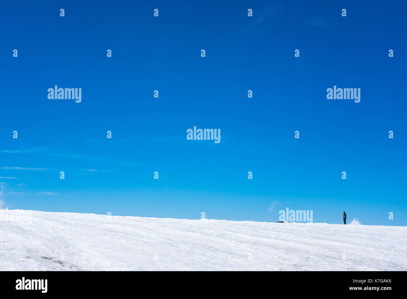 Homme trekking sur la montagne de neige avec ciel bleu Banque D'Images