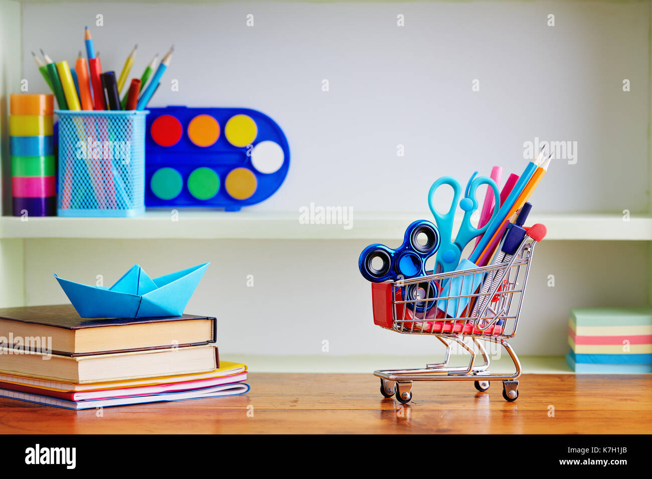 Retour à l'école panier de provisions sur la table en bois. panier rempli de avec des fournitures scolaires. Banque D'Images