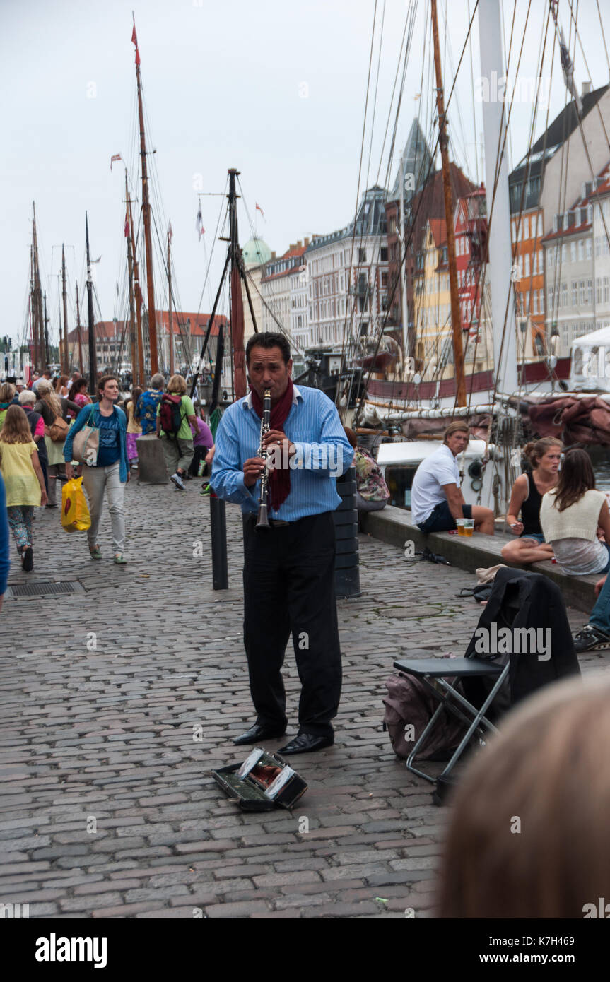 Un homme jouant de son instrument dans le port de Copenhague, Danemark. Banque D'Images