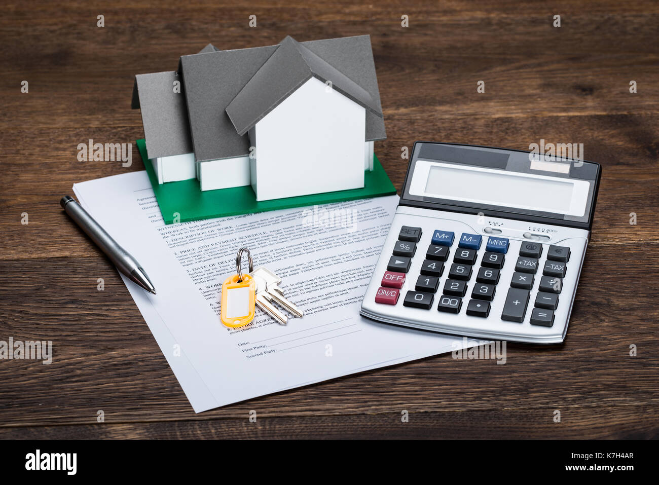 Chambre modèle sur papier du contrat avec des clés et calculatrice conservés sur un bureau en bois Banque D'Images