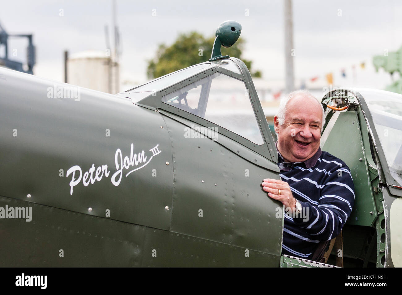 En Angleterre, Chatham Dockyard. Événement, hommage aux années 40. Un homme âgé, souriant alors qu'il était assis dans le cockpit d'un chasseur Spitfire de la seconde guerre mondiale et qui pose pour une photo. Banque D'Images