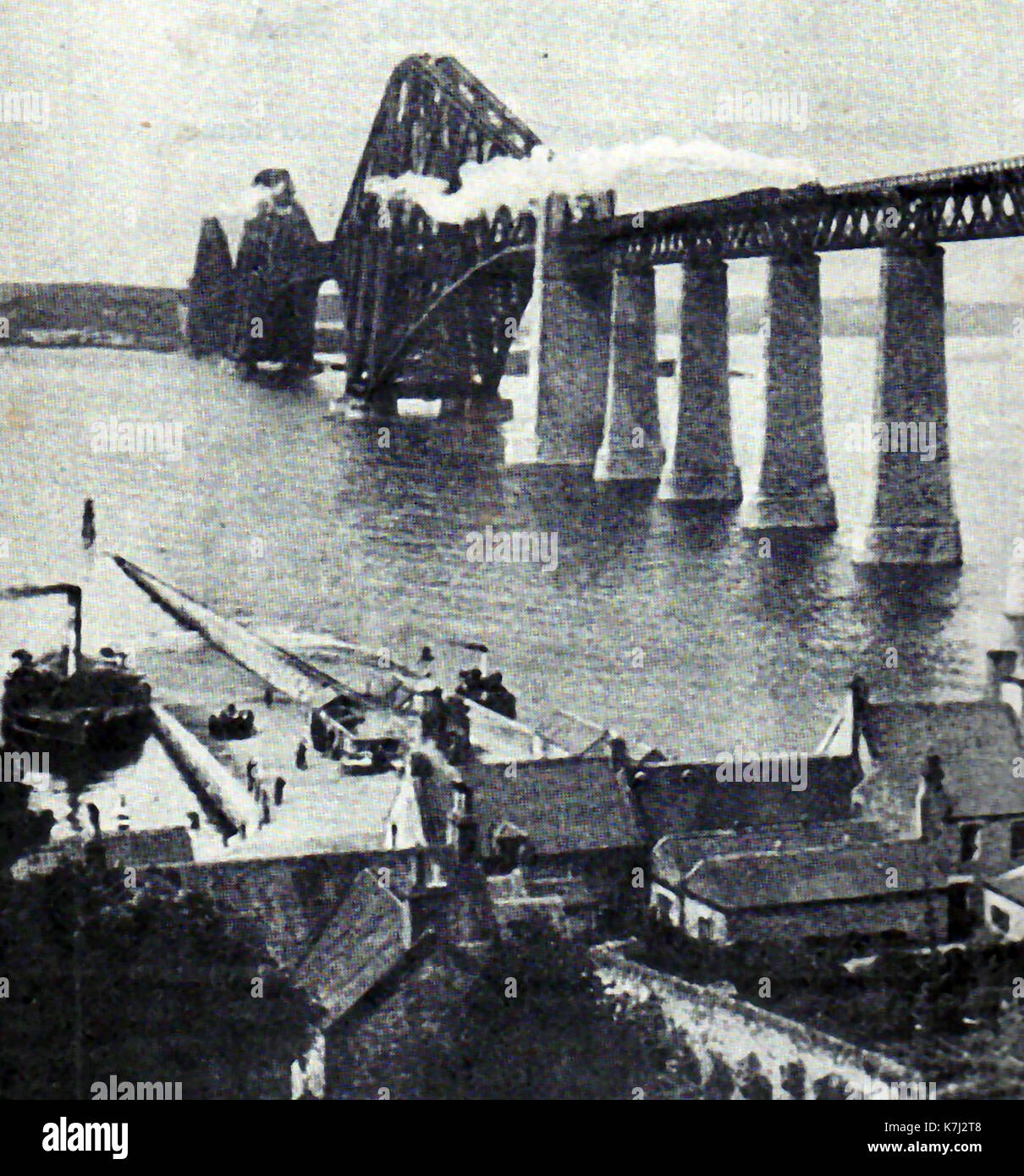 1914 - Le Pont du Forth en Écosse avec un train à vapeur le traversant venant vers le ferry ferry terminal en bas à gauche de l'image. Banque D'Images