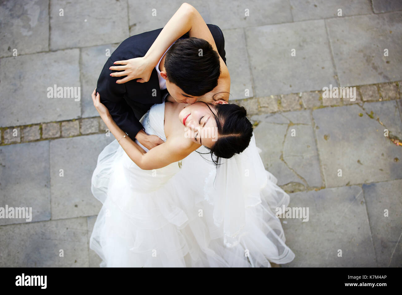 Young Asian Bride and Groom kissing embrassant la danse, high angle view. Banque D'Images