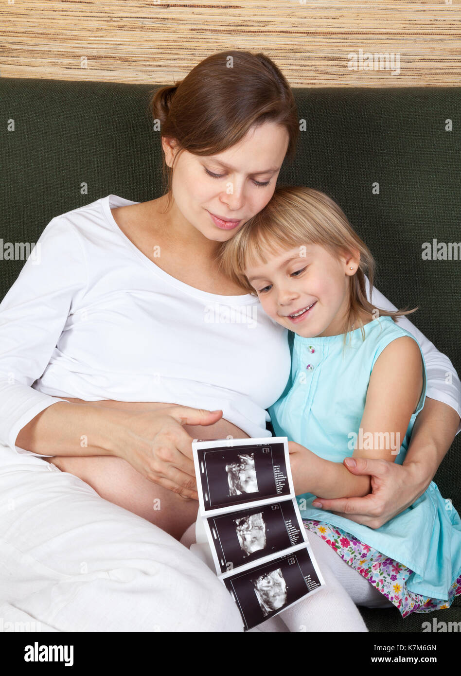 Petite fille avec sa mère enceinte à la recherche à l'échographie d'un fœtus Banque D'Images