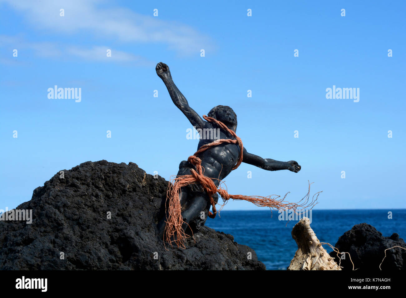 Photo d'une figurine Jésus liée en corde et incrustée dans la roche volcanique sur la côte de Ténérife Banque D'Images