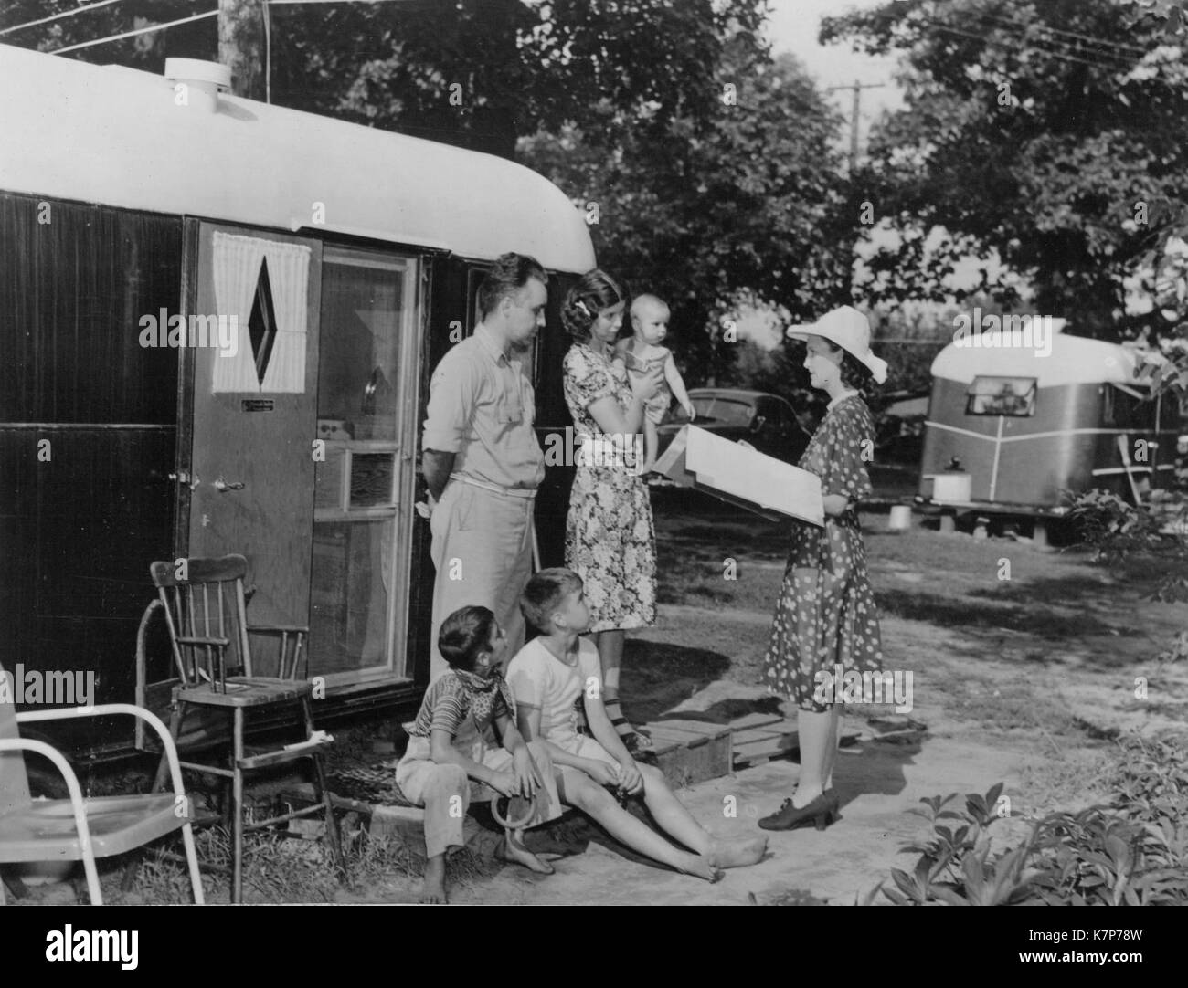 Un recenseur de sexe féminin, et des recenseurs, chefs des familles dans un parc à roulottes transitoire pour le recensement de 1940, 1940. Banque D'Images