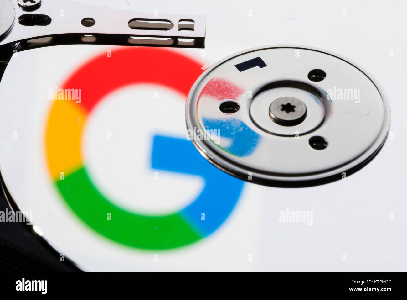 Close-up du disque dur de l'ordinateur d'un disque ouvert, avec la réflexion de la logo Google sur la surface du disque. Banque D'Images